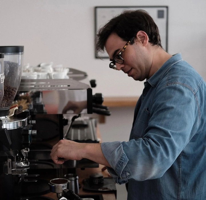 υπαλληλος φτιαχνει καφε στη μηχανη του καφε
